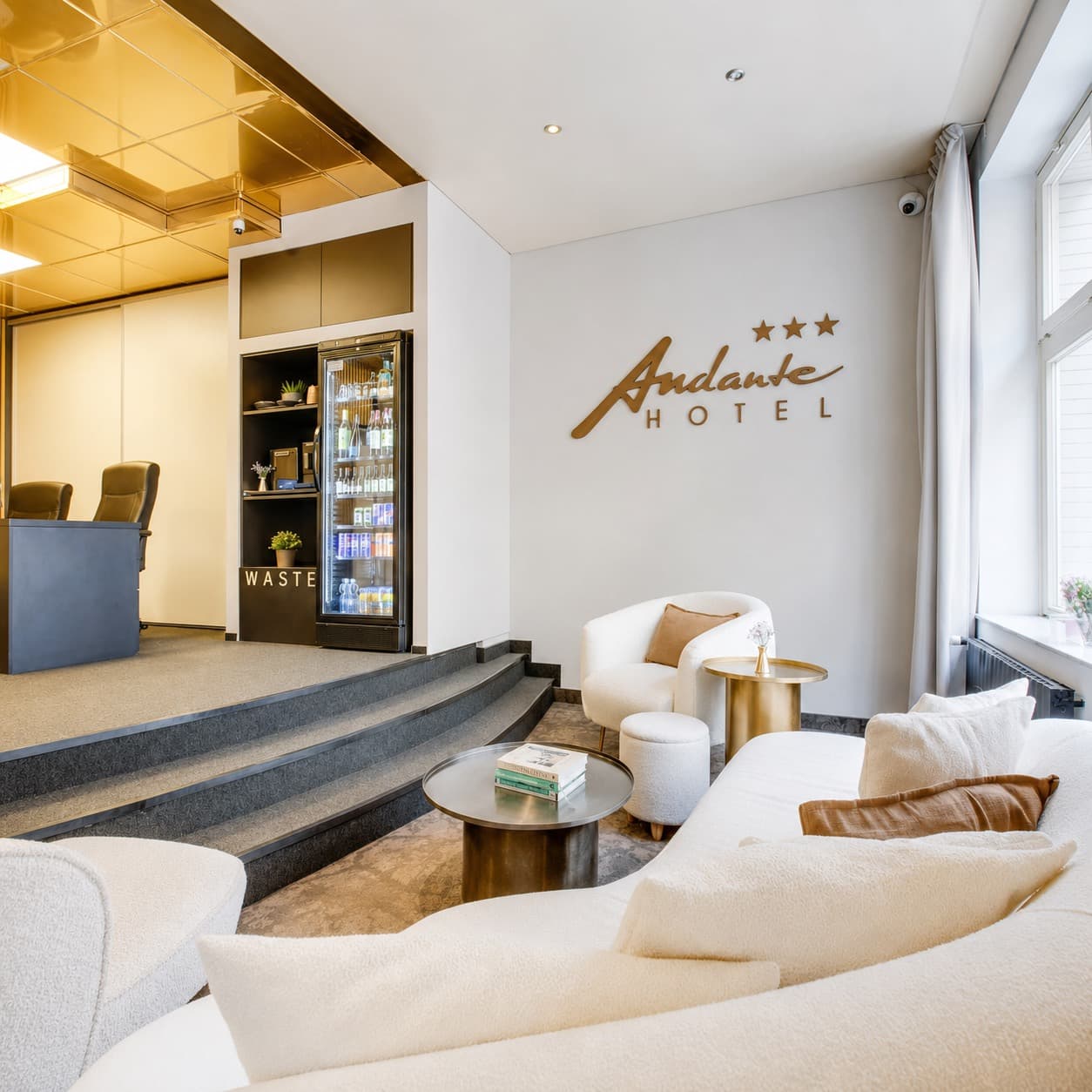 Bronzové prostorové logo Andante Hotel na stěně hotelové lobby