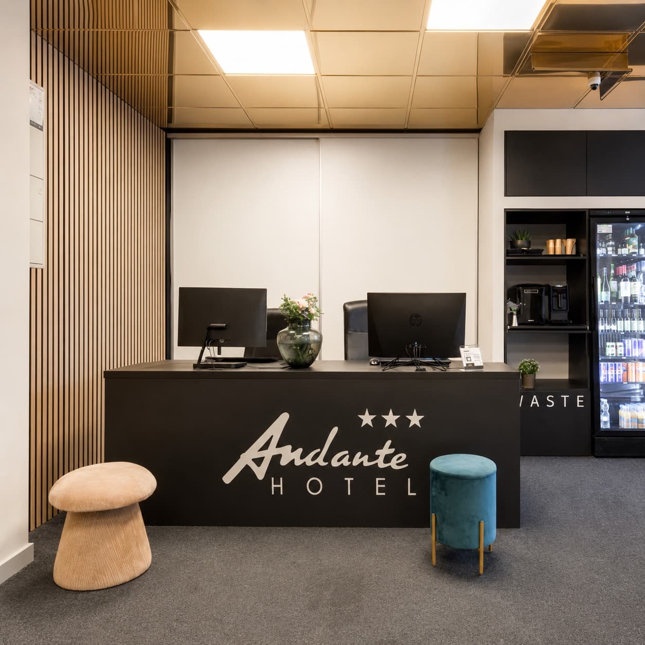 Černý recepční pult hotelu Andante s bílým polepem loga