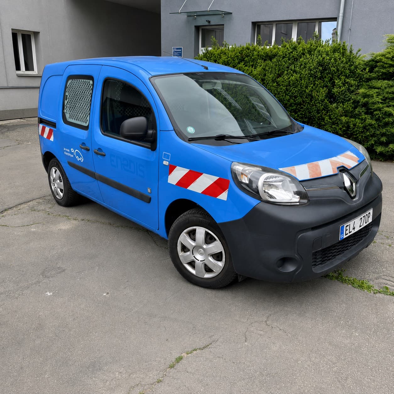 Modrá užitková dodávka s výstražnými šrafy a cizím logem před polepem